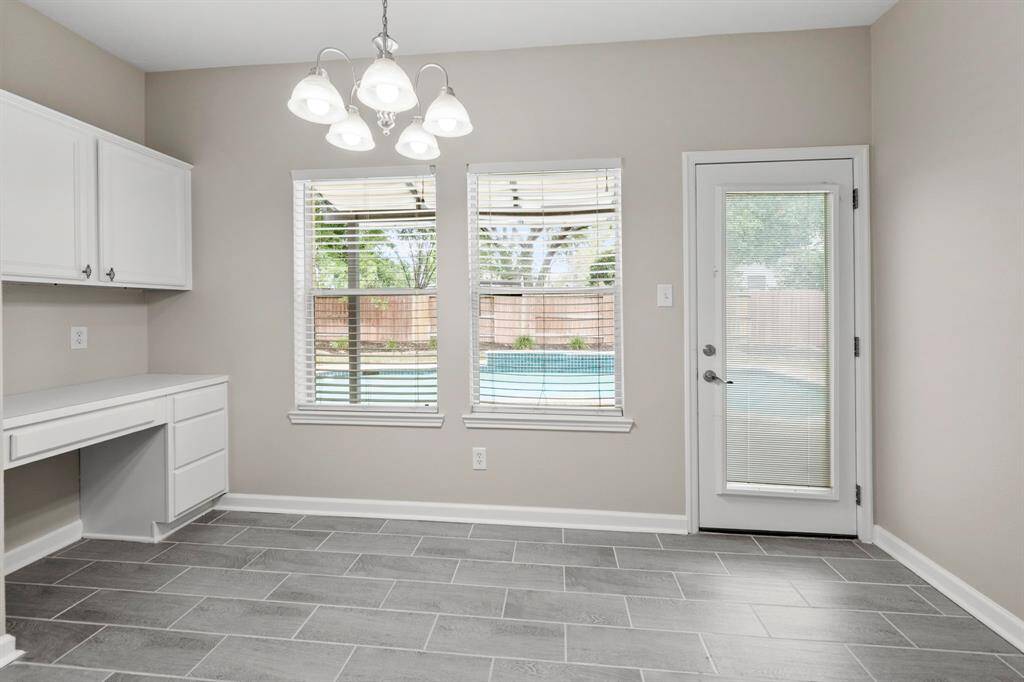 View from the informal dining area overlooking the pantry doors, the build in desk, and the patio door.