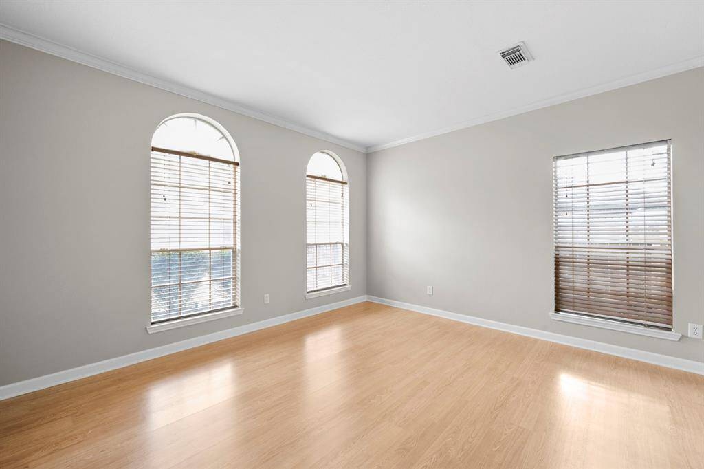 View of the formal living room, featuring crown molding, art niche, nice maple floors, and plenty of natural light.