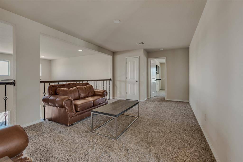 The space is open, featuring a railing that overlooks the lower level, and has access to additional rooms.
