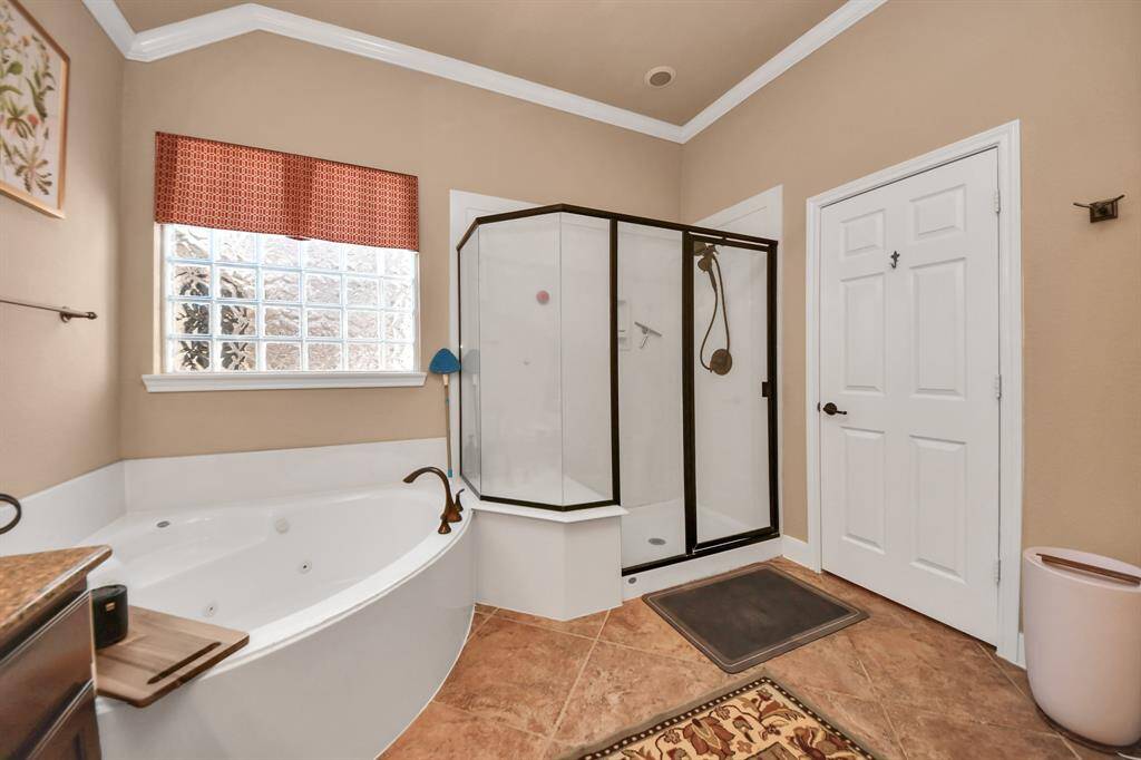 Primary Bathroom has dual sinks and jetted tub along with stand-up shower