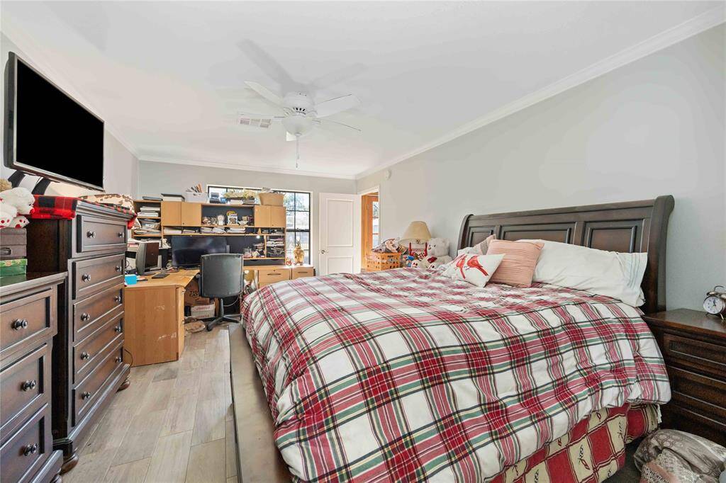 This cozy bedroom features ample natural light from the window, and a ceiling fan for comfort.