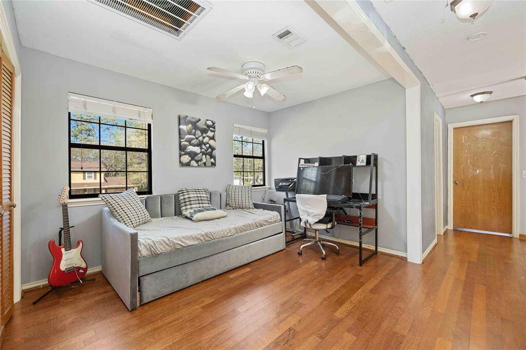This bright room features hardwood floors, large windows provide ample natural light, and a ceiling fan ensures comfort. Perfect as a home office or guest room.