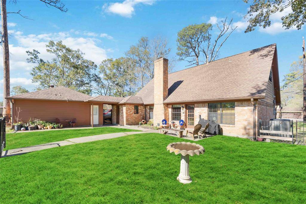 This charming home features a spacious backyard with lush green grass, a cozy patio area, and a classic brick exterior. Perfect for outdoor relaxation and entertaining.