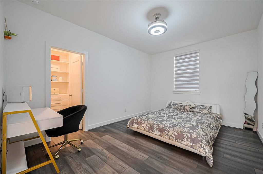 This spacious sleeping area features sleek flooring, a window for natural light, and a full entry closet—ideal for guests or residents seeking a private, quiet escape.