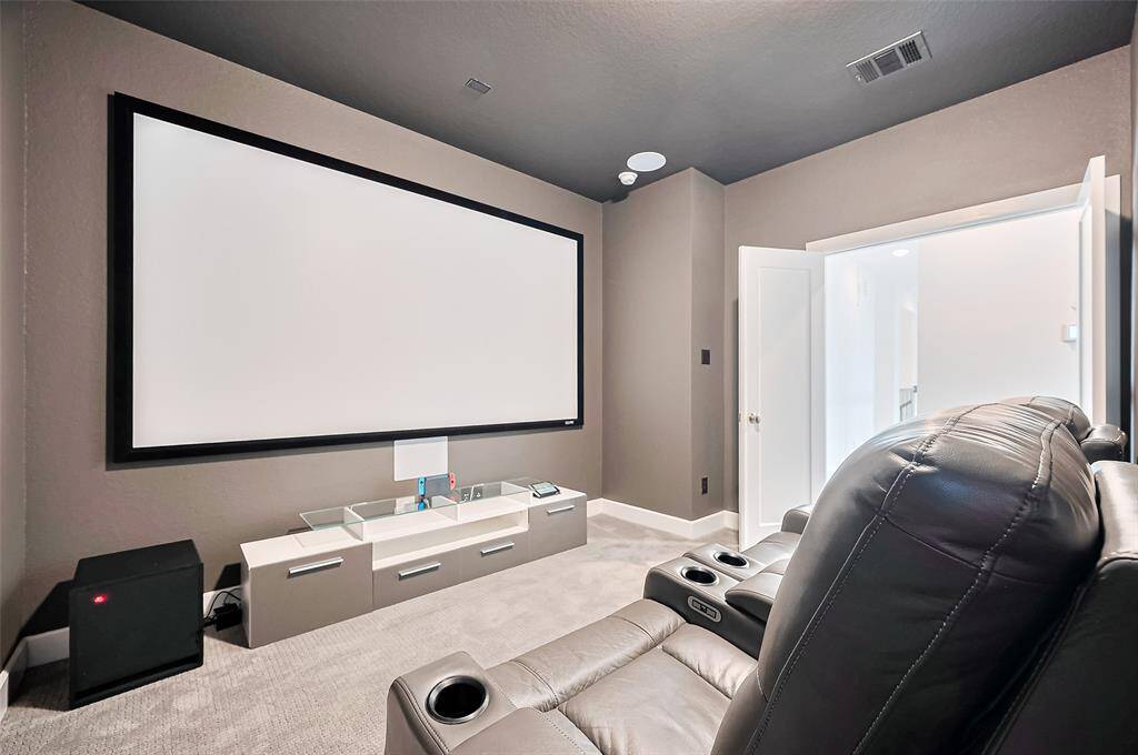 Tucked behind double doors, this cozy media room is wrapped in soft gray tones, with a deeper hue on the ceiling to create an immersive, theater-like atmosphere.