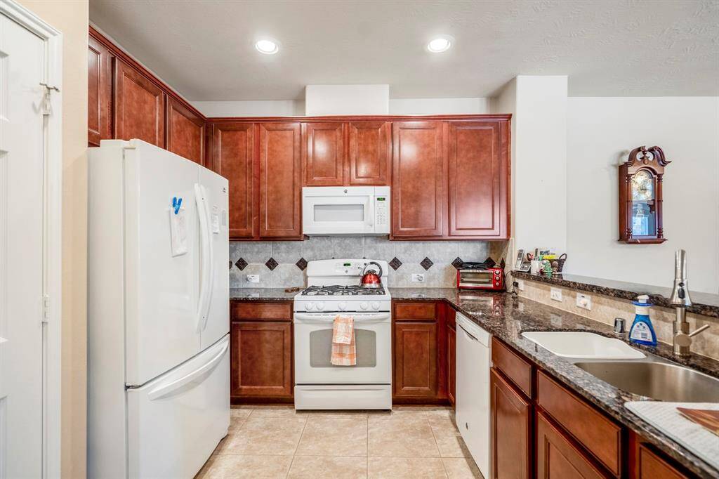 There is plenty of granite counter top space and nice complimentary backsplash as well as dual sinks.