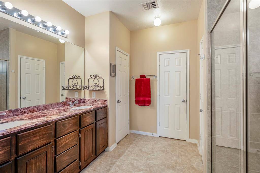 The primary bathroom is large and has dual sinks, a large mirror and seperate shower.