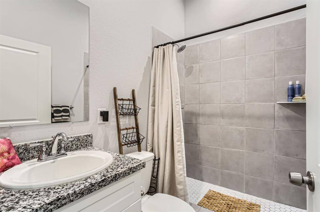 The primary bathroom offers granite counter tops, an oversized shower and tankless water heater.