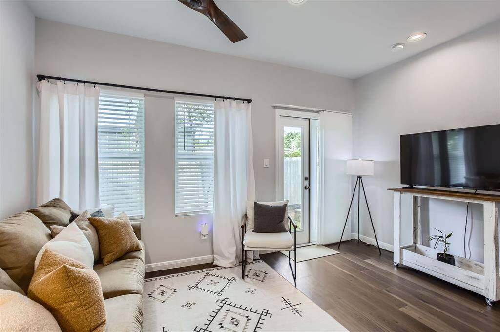 The family room features rich luxury vinyl flooring, plenty of natural light and sleek, modern ceiling fan.