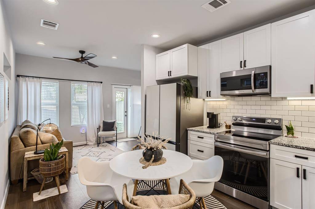 The light, bright kitchen offers granite countertops and tile backsplash.