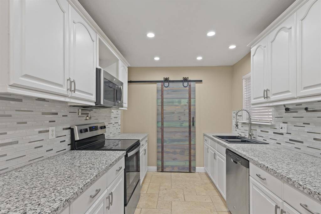 Updated kitchen features granite countertops, pot filler over the stove, and stainless steel appliances.