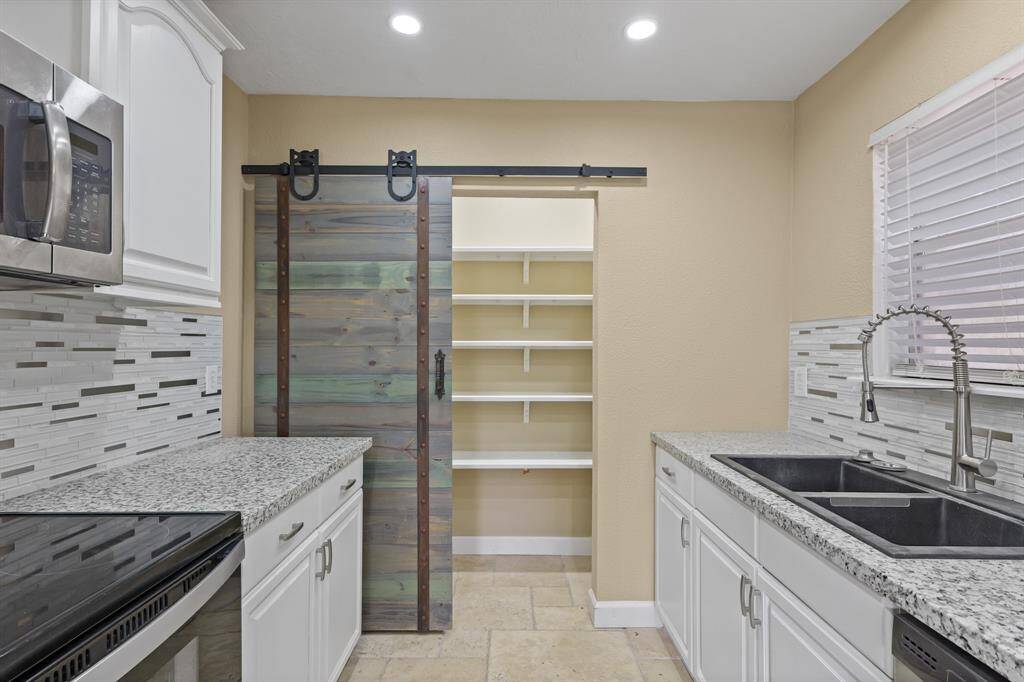 Barn door slides to reveal large pantry.