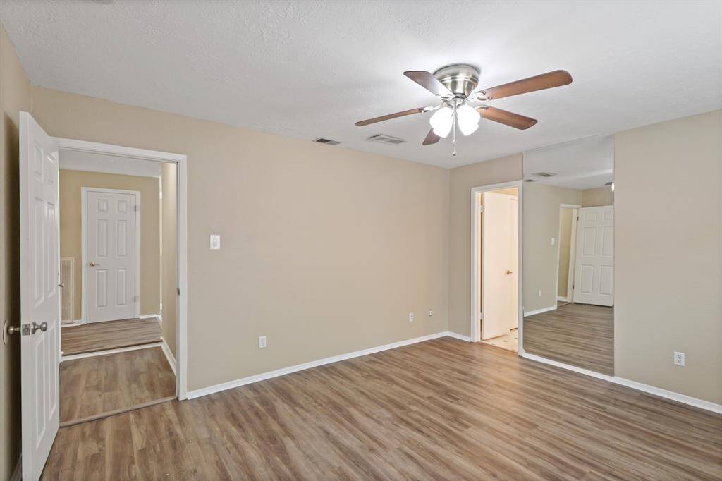 Large primary bedroom features updated ceiling fan and en suite bath.