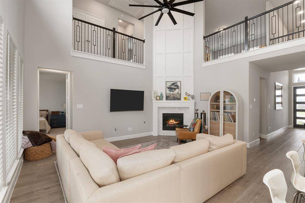 At the heart of the home lies a spacious family room with soaring cathedral ceilings, highlighted by a striking modern ceiling fan.