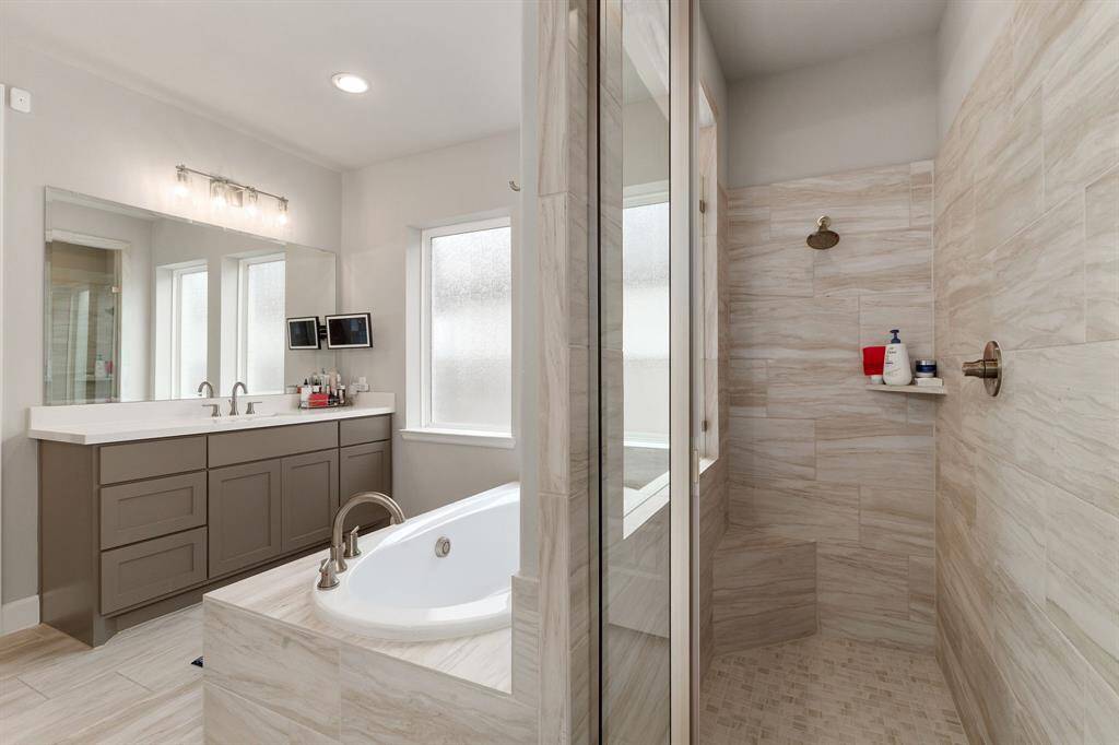 The separate walk-in shower provides a revitalizing alternative, featuring a sleek modern glass enclosure that adds a touch of sophistication. Inside, premium finishes such as polished tile, contemporary fixtures, and a built-in bench create a spa-like experience, perfect for starting your day energized or unwinding in comfort.
