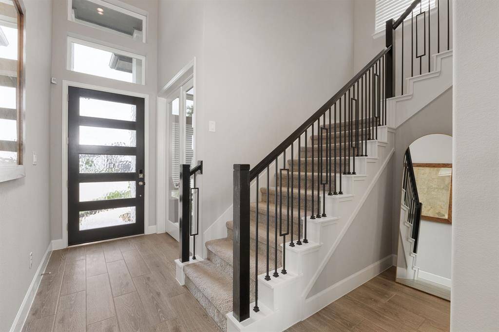 Ascend the plush carpeted staircase, highlighted by a sleek modern handrail, and discover what awaits upstairs.