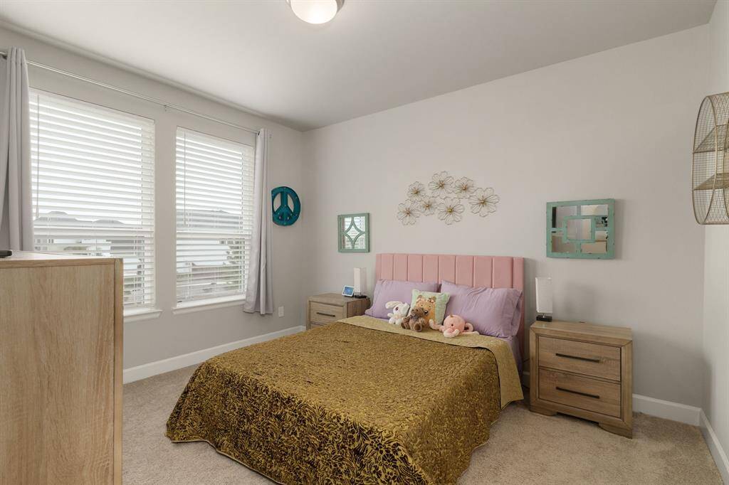 This final spacious secondary bedroom is designed with comfort in mind, featuring plush carpeting, high ceiling that enhances the room’s open feel, and large windows that welcome abundant natural light.