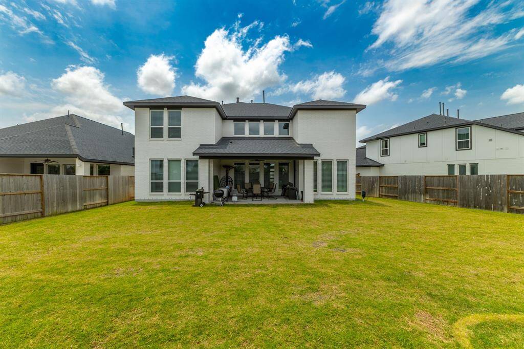 Overlooking the backyard is a large covered patio—an ideal space for outdoor dining or entertaining guests in any weather.