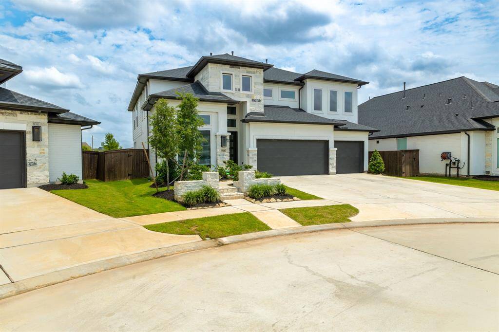 An expansive triple-wide driveway leads to a spacious three-car attached garage, providing ample parking and easy access.