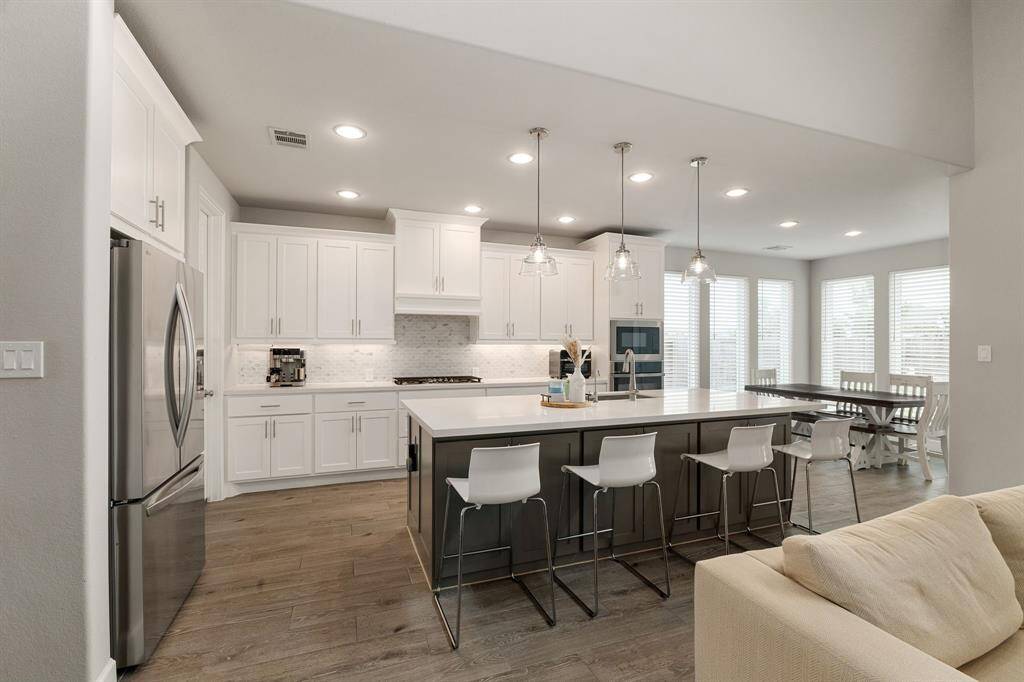 Sleek and spacious, this open-concept kitchen features a large quartz island, stainless steel appliances, and abundant natural light. Seamlessly flows into the bright dining area with oversized windows.