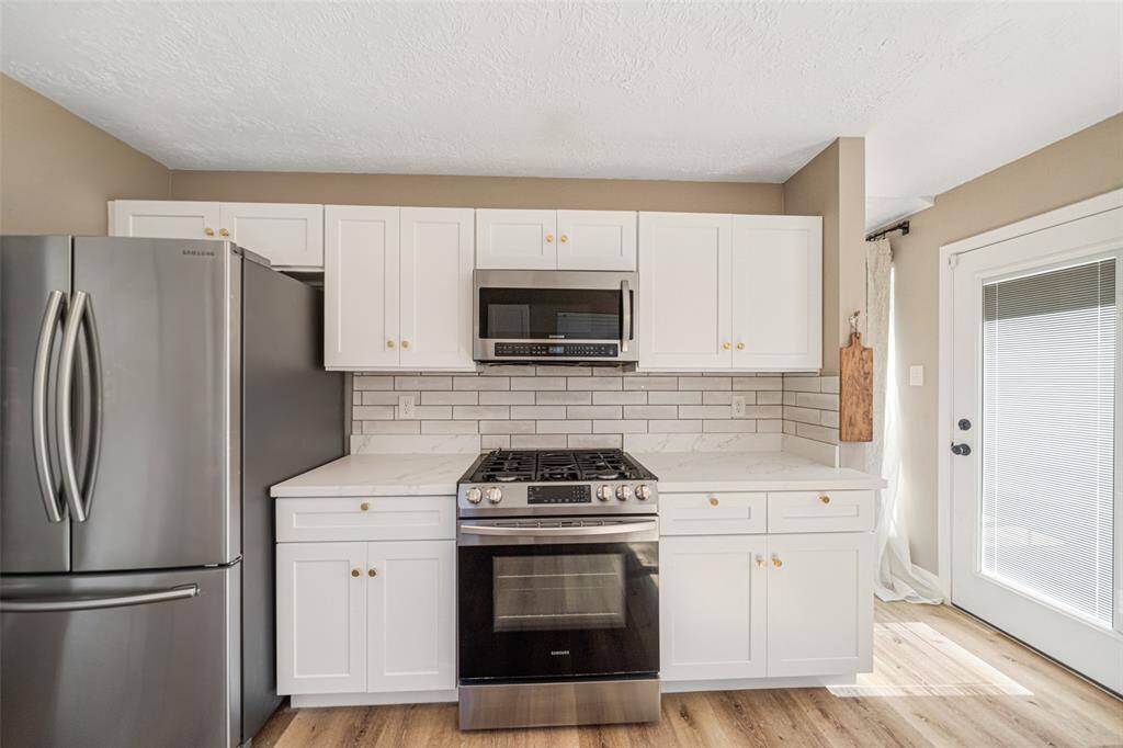 Amazing kitchen featuring stainless steel appliances, Caracara countertops, a farmhouse sink and  a gorgeous backsplash