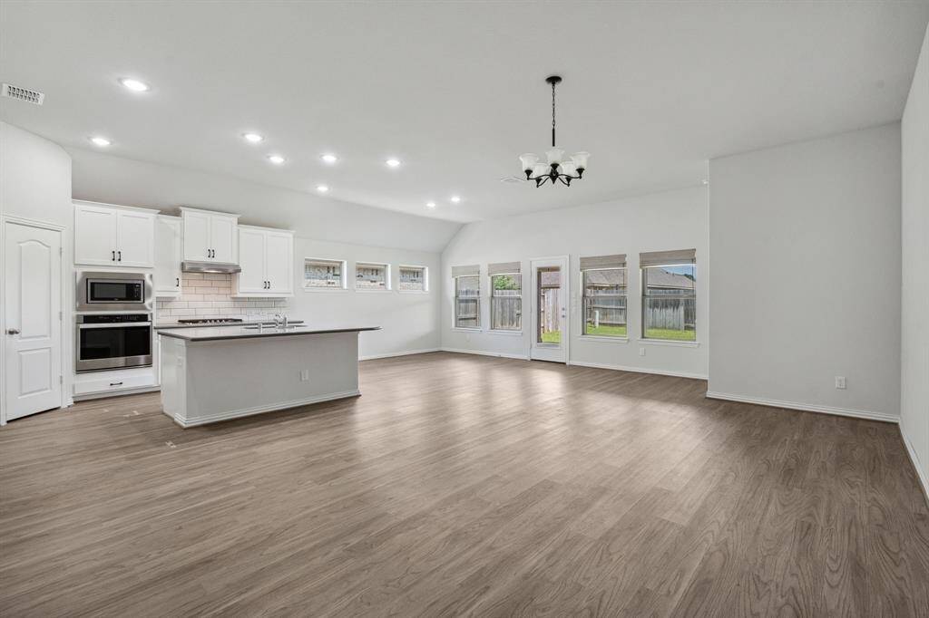 Open space with primary living area, kitchen and dining