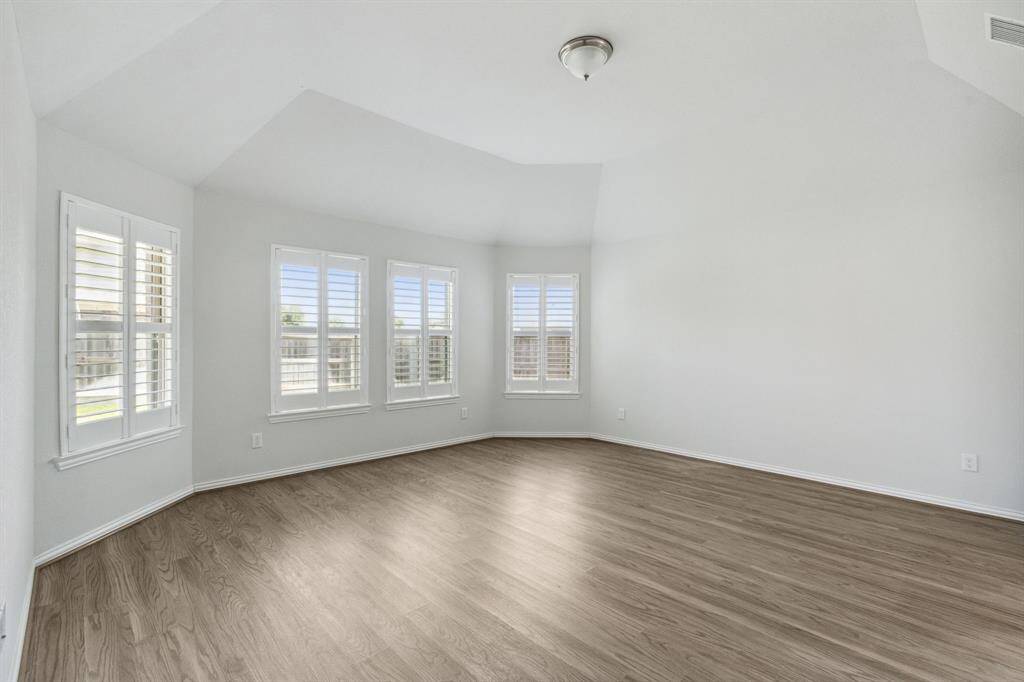 Primary bedroom has plantation shutters offering a lot of natural light