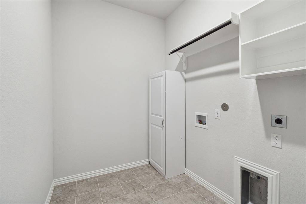 Laundry room with shelves and cabinets.