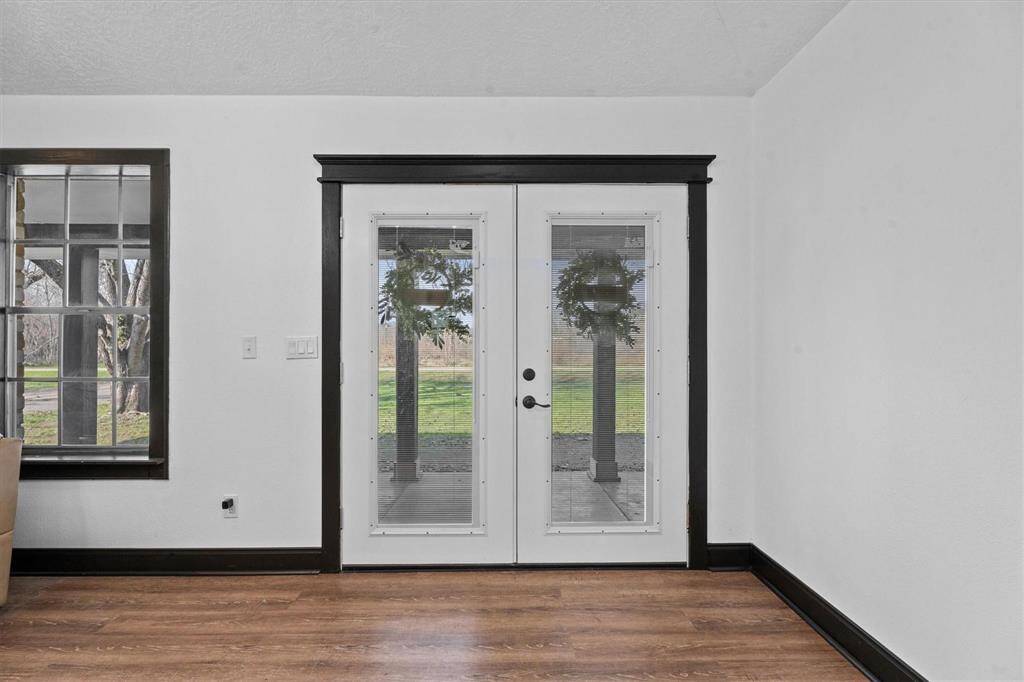 Elegant French doors infuse the family room with natural light and also offer convenient access to the outdoor oasis, seamlessly connecting indoor and outdoor living spaces.
