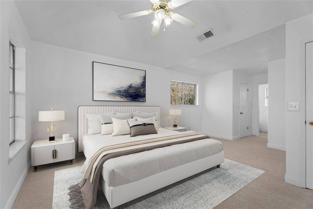 The virtually staged primary bedroom exudes comfort and space, bathed in natural light from generous windows that frame peaceful views of the front and side yards- your own private retreat.