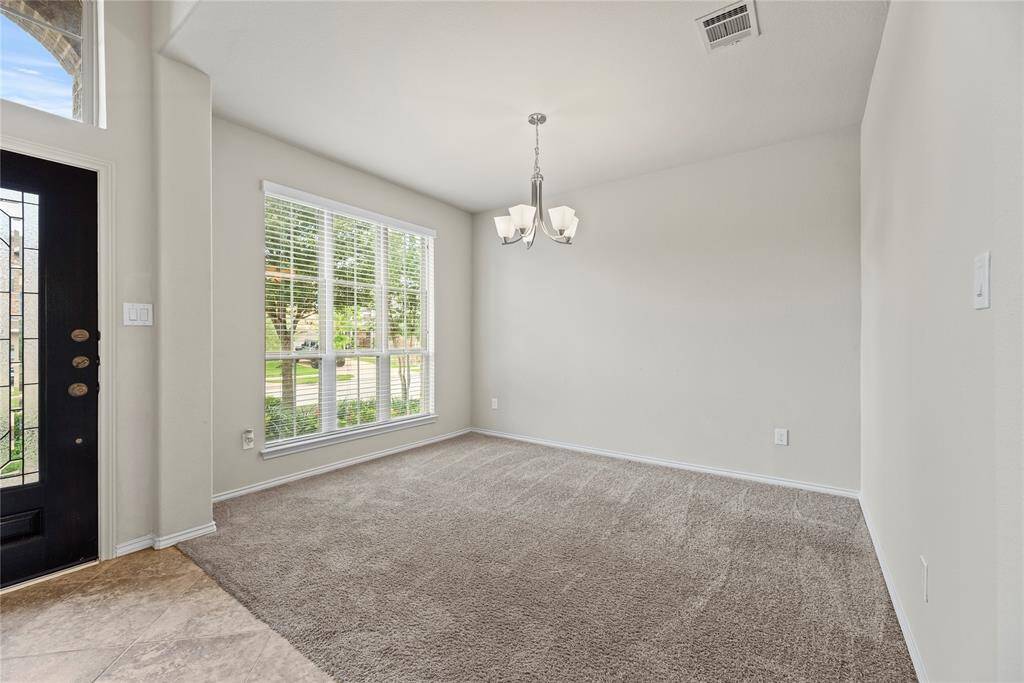 Features a formal dining room near the two-story entry, open family room adorned with ceramic tile flooring and expansive windows.