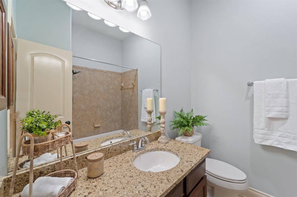 Spacious full hallway bath featuring elegant granite counters and sleek fixtures.Includes a convenient medicine cabinet for extra storage and functionality.