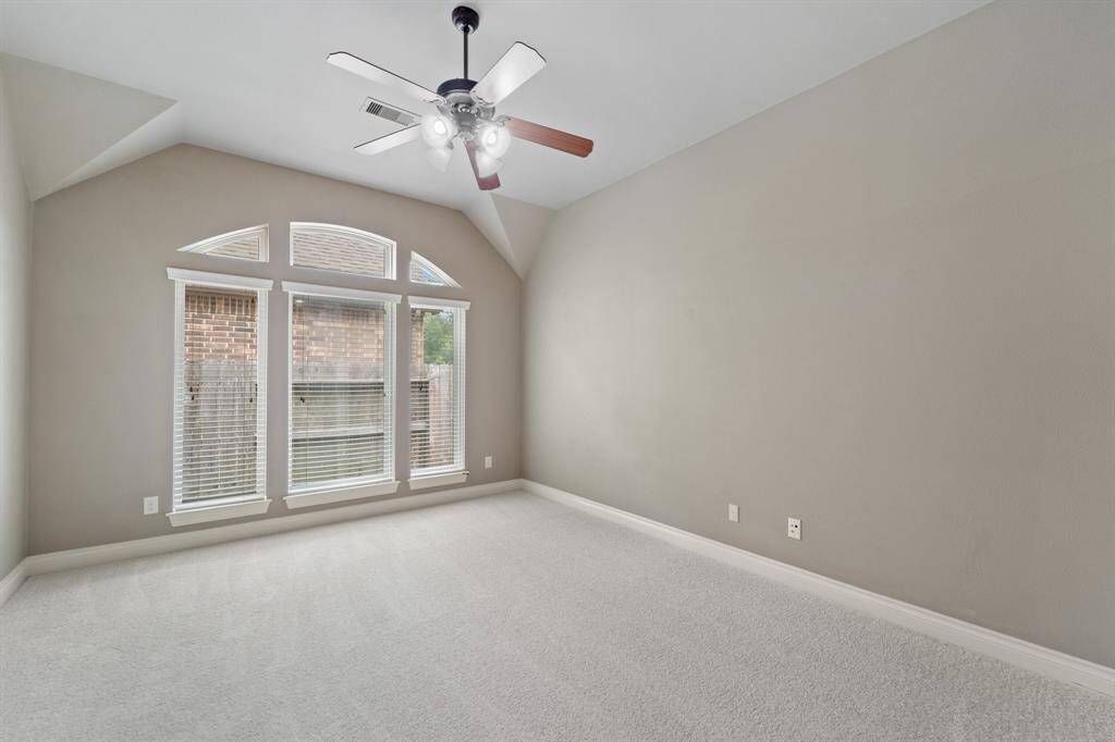 Spacious game/media room with elegant glass double doors, a ceiling fan, and brand-new carpet (installed May 2025).An ideal space for entertainment and relaxation, offering comfort and style.