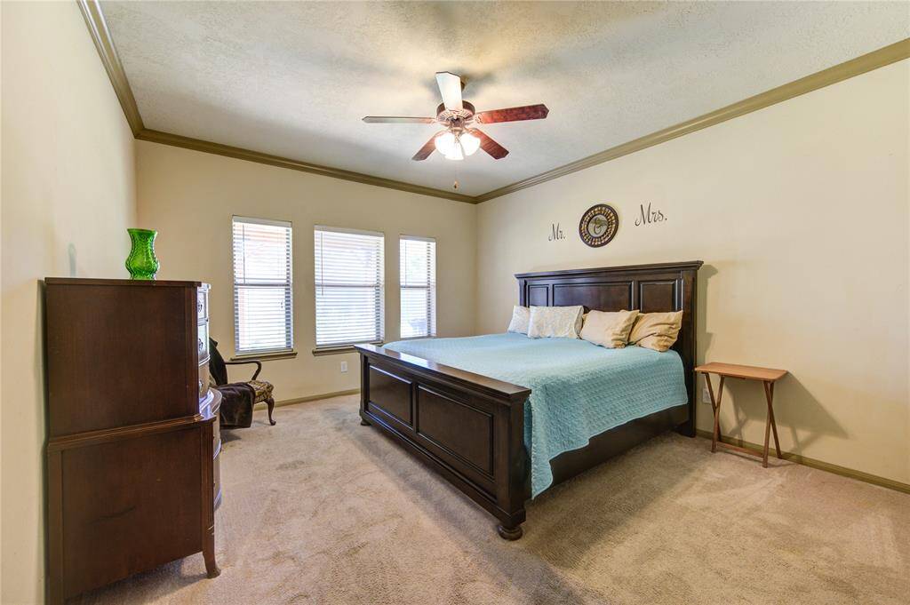 1st Floor Primary Bedroom with crown molding and natural light