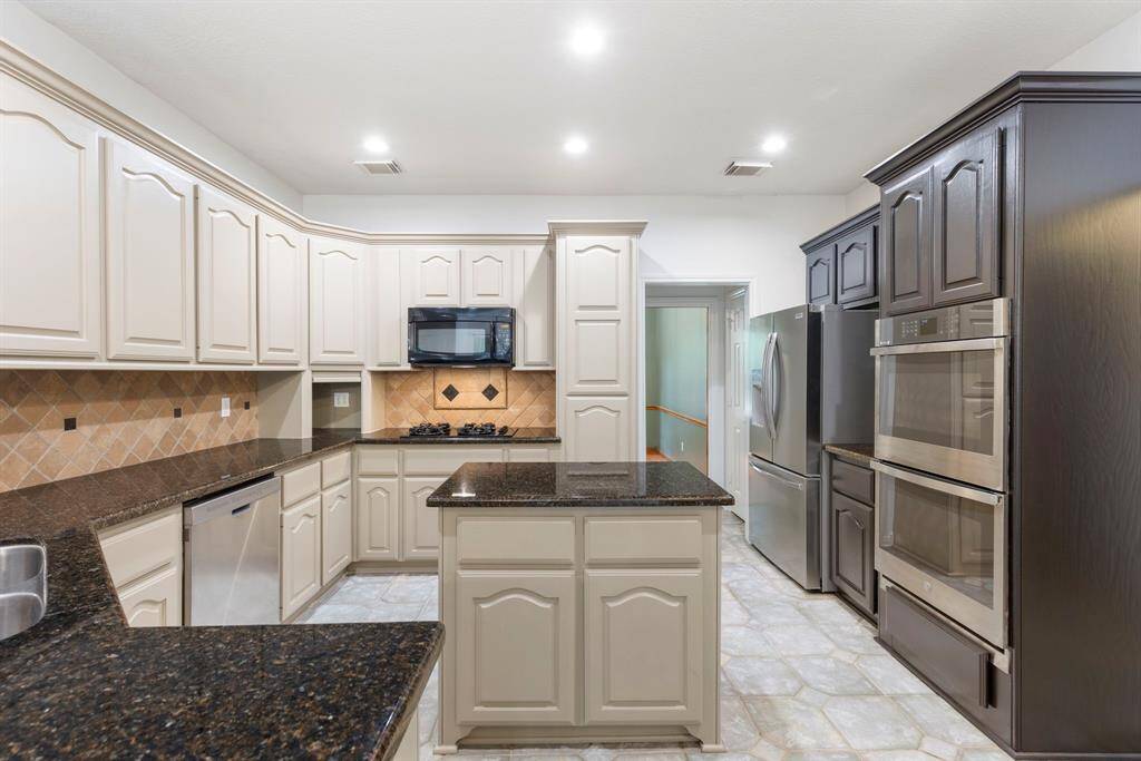 This kitchen features elegant cabinetry and granite countertops, complemented by recently updated stainless steel appliances,