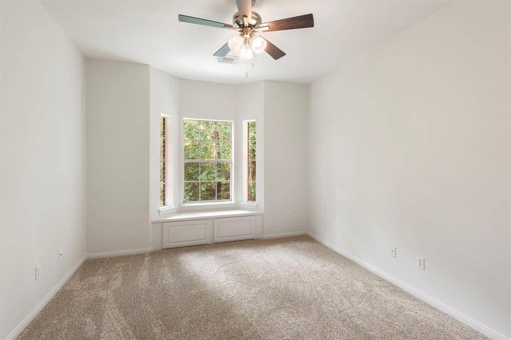 Spacious fourth bedroom featuring a large window for natural light and plush carpeting for comfort.