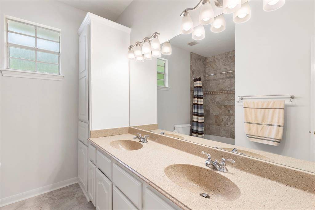 Upstairs bathroom with elegant double vanity and modern fixtures.
