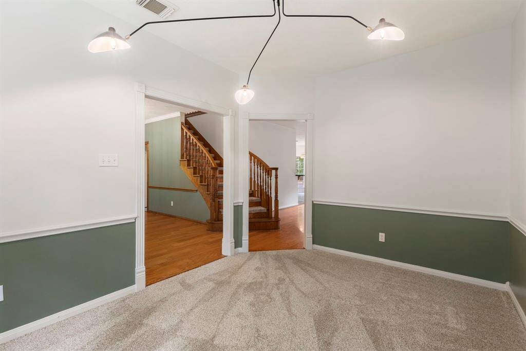 Bright and inviting office space featuring plush carpeting and stylish two-tone walls, perfect for productivity and focus. Enjoy the modern lighting and seamless access to the main living areas.