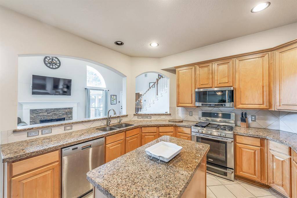 Gas stove, expansive counter space, up-to-date finishes, and an open floorplan make this kitchen the perfect "hub," central to the activities of daily life.