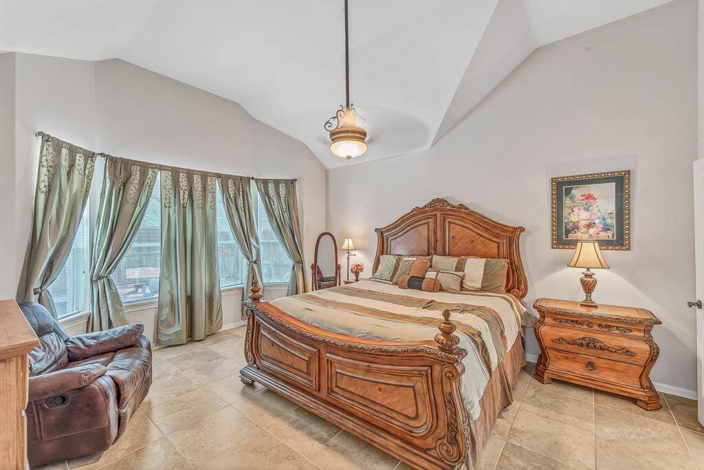 Soaring ceilings, architectural interest, and natural light are highlights of the master suite, located on the first floor. Relaxed elegance is the best way to describe this space. Neutral 18-inch tiles continue into this space from the public spaces of the home. No carpet!