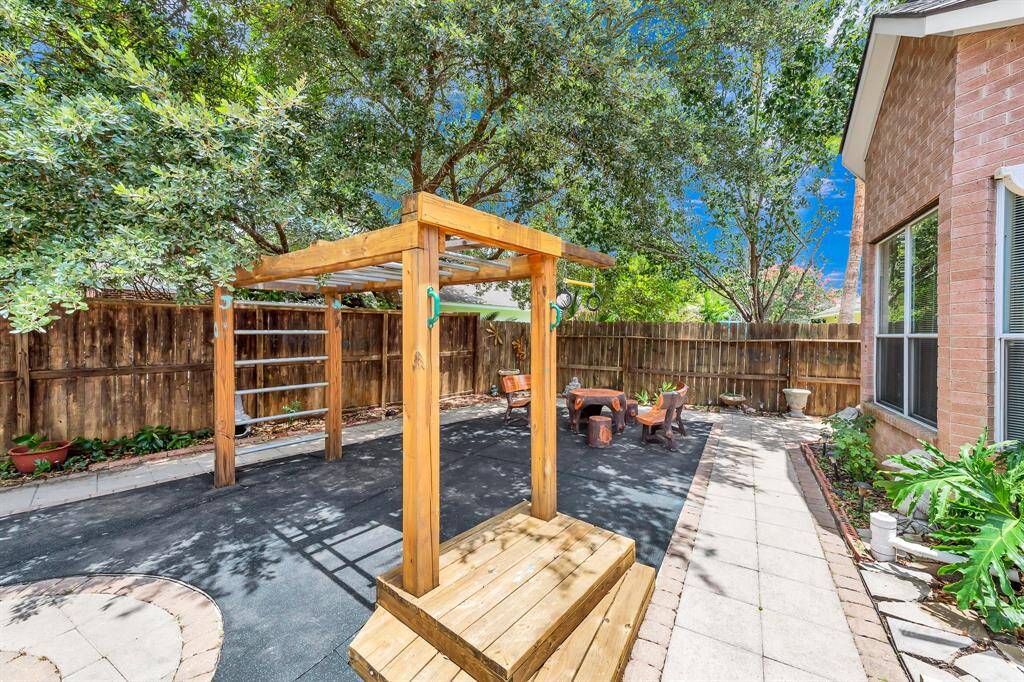 The soft landing surface beneath the playscape extends to the seating area beyond.  Perfect for running, jumping, and playing beneath the shade of mature trees.
