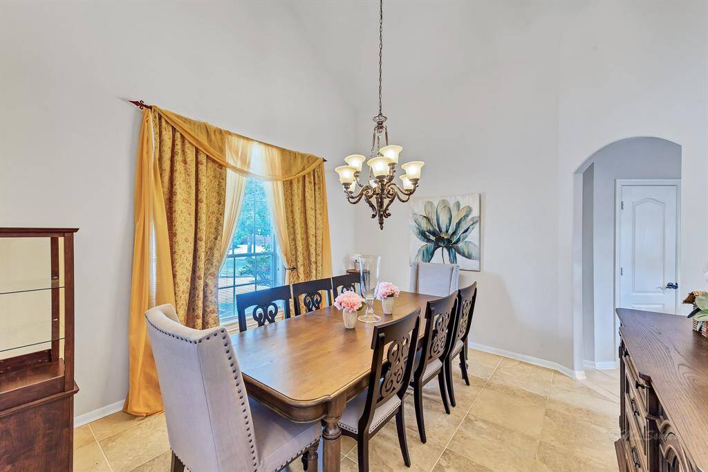 Light and bright dining room with seating for 8 and matching dining table and serving buffet with storage. High ceilings and large windows make this an inviting space for entertaining.