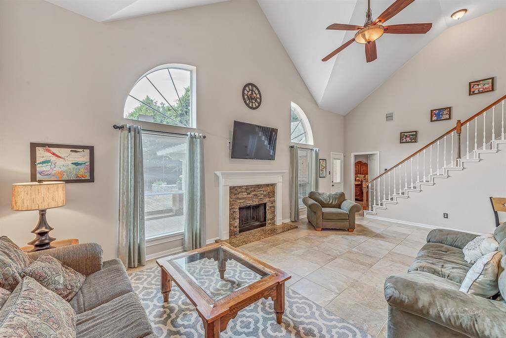 High ceilings and 18-inch tile provide a neutral backdrop for the living room. View to the master suite entry and stairs leading to the gameroom and secondary bedrooms.