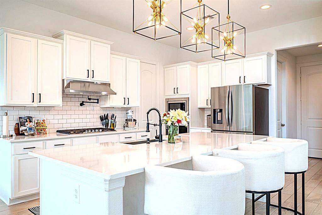 White cabinets, designer backsplash and breakfast seating at the island