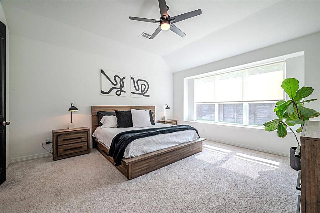 Spacious primary bedroom full of natural light