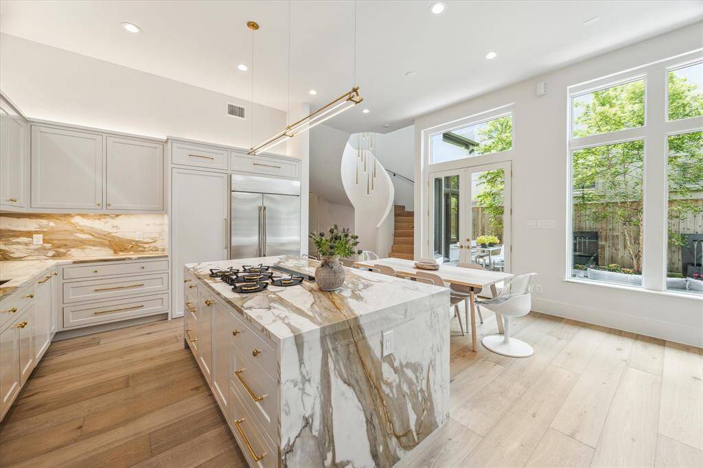 A closer look at the sleek chef’s kitchen—where waterfall porcelain counters, brass fixtures, and custom cabinetry combine luxury with everyday functionality.