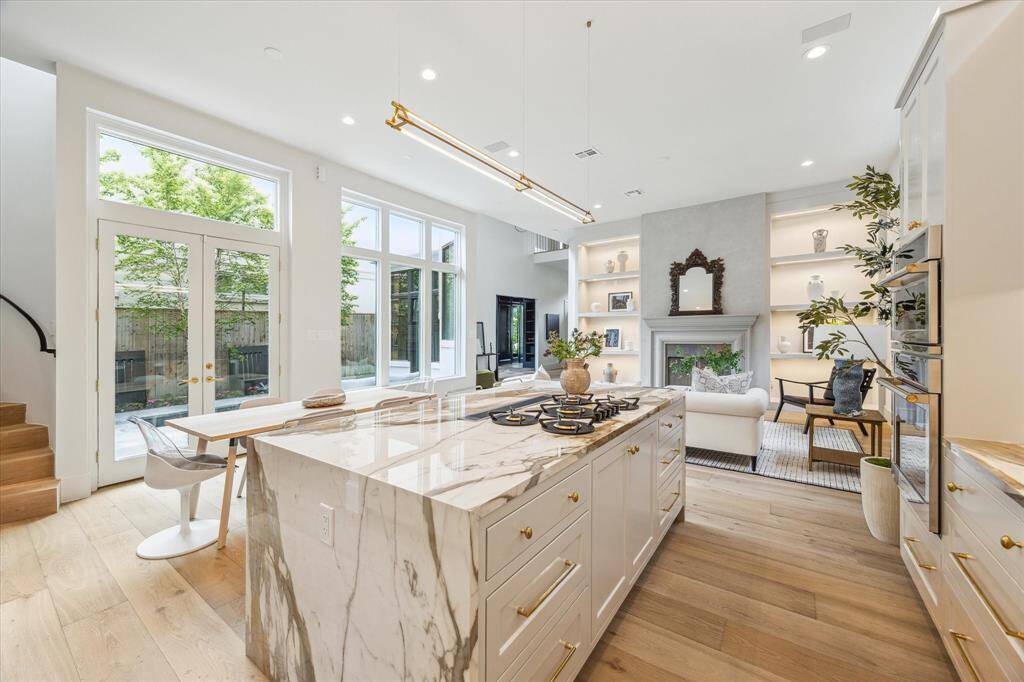 The breakfast area and kitchen overlook the backyard through walls of glass, inviting effortless indoor-outdoor entertaining.