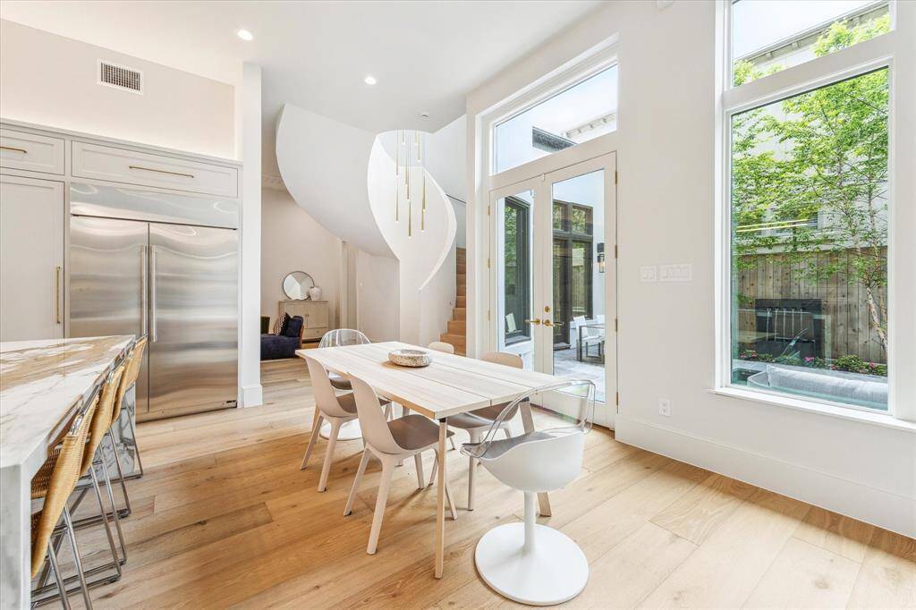 Savor your morning coffee or host dinner with ease—this dining area invites relaxed elegance with abundant sunlight and yard views.