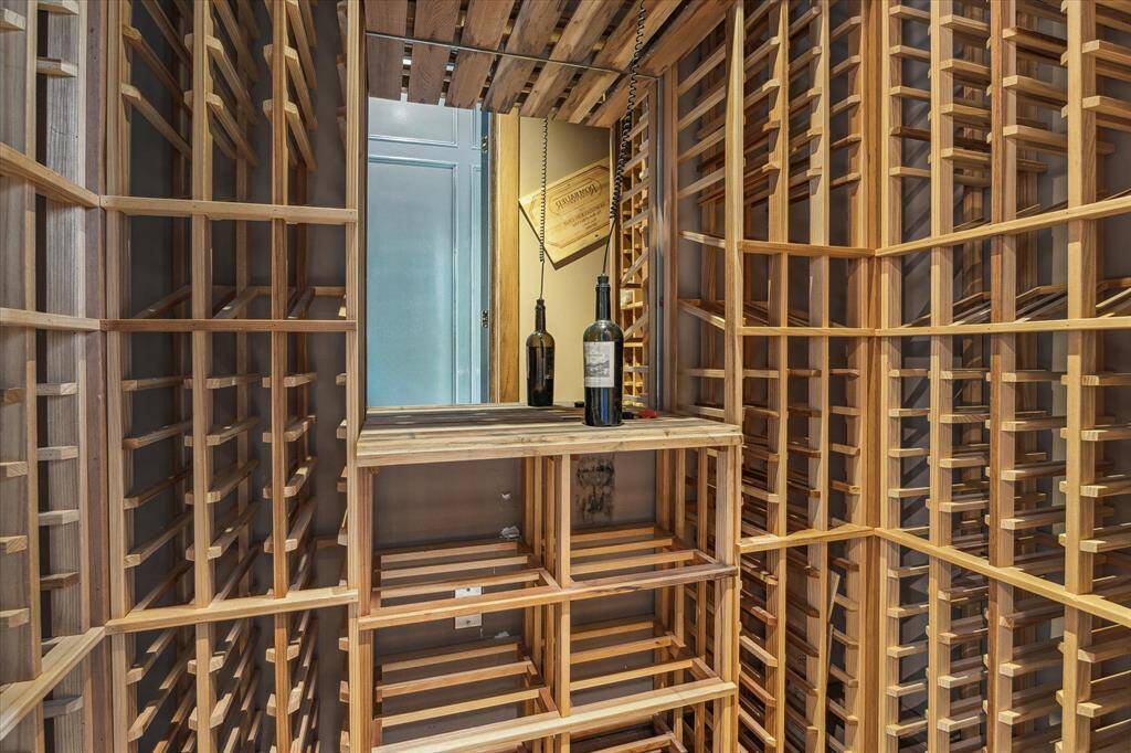 A sophisticated wine room with custom wood racking and mirrored backdrop—perfect for collectors and entertainers alike.