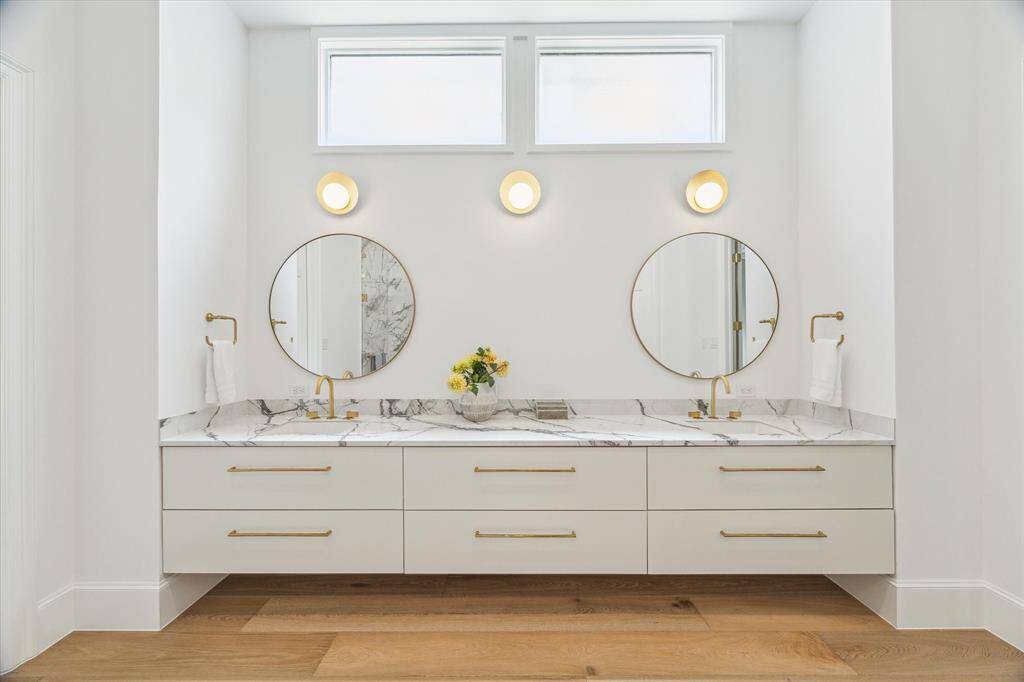 The clean lines of the floating double vanity and symmetrical mirrors bring understated luxury to the primary bath’s dressing area.
